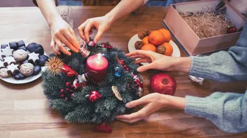 Kerzenkranz wird mit Dekorationen von Händen geschmückt, Weihnachten.