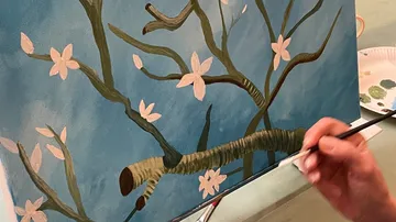 Blütenzweig wird auf Leinwand mit Pinsel bemalt, blaue Hintergrund.