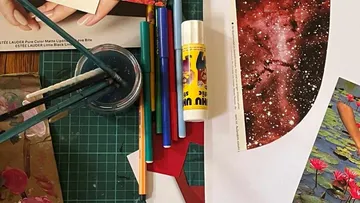 Colored pencils and glue lie on a table in front of materials.