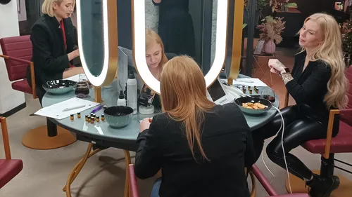 Women engaged in activities at circular mirror table.