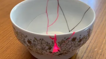 Keramikschale mit pinker Kintsugi-Reparatur, Blumenmuster.