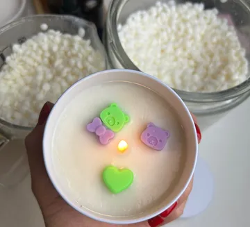 Decorative candle with colorful bear shapes.