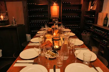 Ein gedeckter Tisch für das Abendessen in einem Weinkeller.