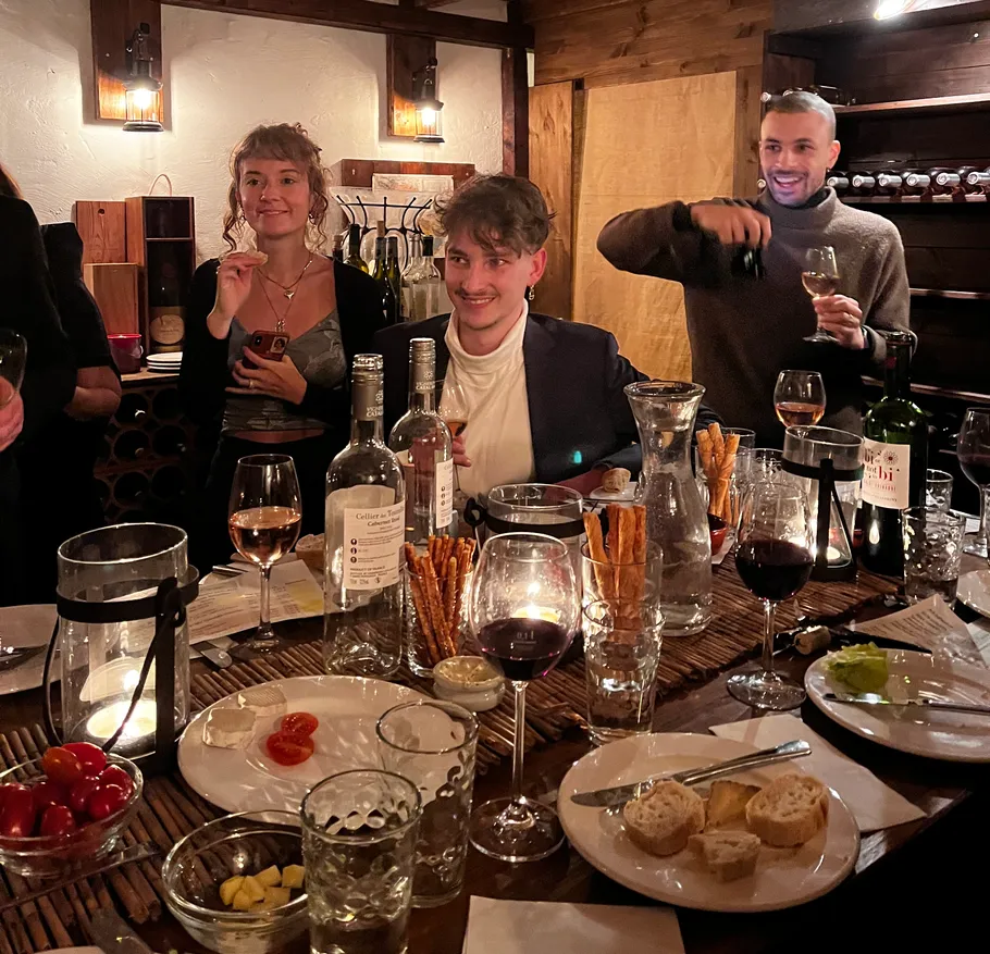Tisch mit Getränken, Speisen und feiernden Personen in einer Restaurantatmosphäre.