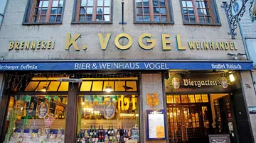 Brauerei mit Schildern, Tischen und Flaschen im Fenster.