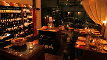 Ein Weinschrank lagert Flaschen, während Kerzenlicht leuchtet.