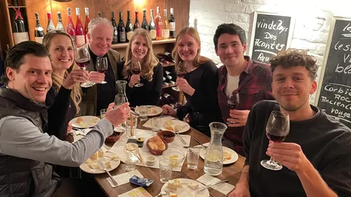 Eine Gruppe von Menschen hebt Gläser in einem Restaurant.