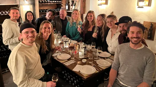 Gruppe von Menschen feiert am Tisch in Weinkeller.