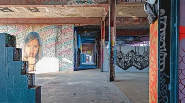 Graffiti-gefüllter Raum mit sichtbaren Wänden und Treppen.