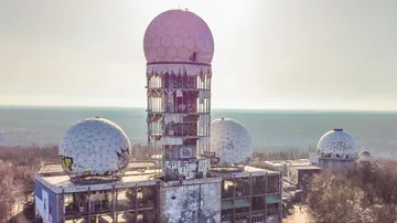 Verlassene Radartürme stehen in einer geschlossenen, bewaldeten Umgebung.