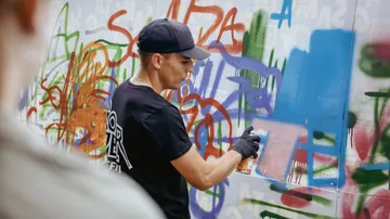 Sprayer sprüht Graffiti