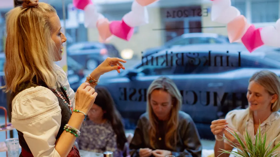 Frau erklärt kreative Aktivitäten in einem geschäftigen Restaurant.