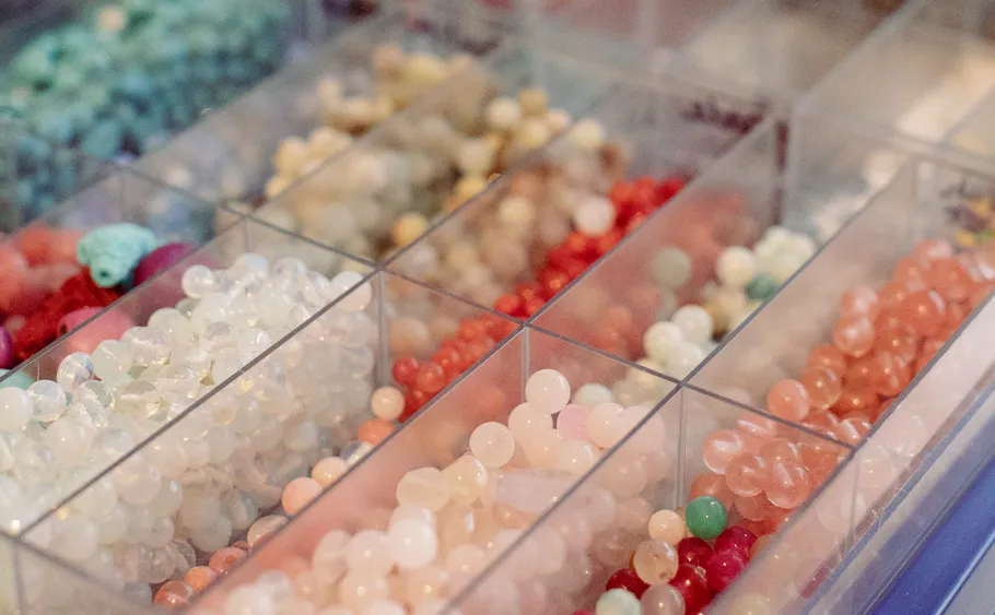 Assorted colorful beads organized in clear compartments.