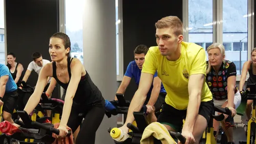 Gruppentraining auf Stationärfahrrädern in einem Fitnessstudio.