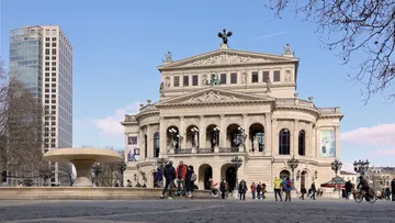 Historic building with people in front of it under clear skies.