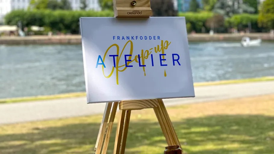 There is a sign on a stand by the water.