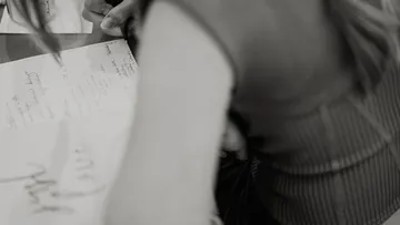 Person writing cursive on a card