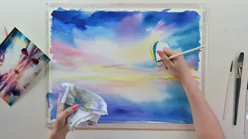 Hand malt einen Wasserfarbenschirm auf weißem Papier.