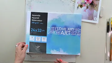 Eine Aquarellskizze wird auf einem Tisch präsentiert.