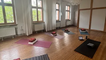 Yogamatten und Kissen sind in einem ruhigen Raum angeordnet.