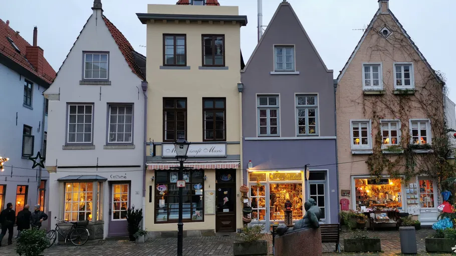 Bunte Häuser in der Stadt mit Lichtern und Geschäften.