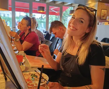 People painting in a relaxed cafe setting.