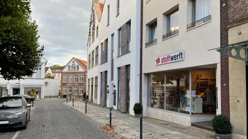 There is a shop called “Stoffwertt” on a quiet street.