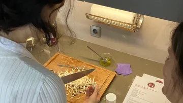 Woman cuts vegetables on a wooden board in the kitchen.