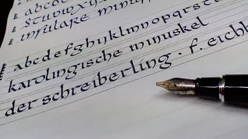 Fountain pen writes on paper in artistic lettering.