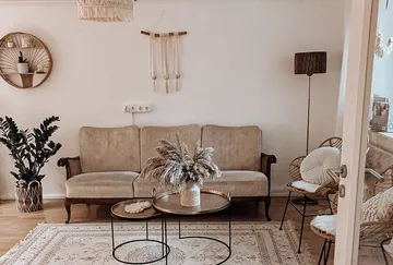 Cozy living room with beige sofa, plants, and decor.