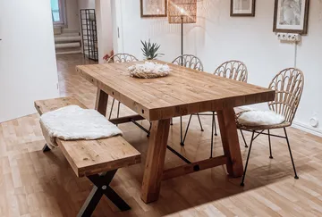 Wooden table with chairs in cozy room.