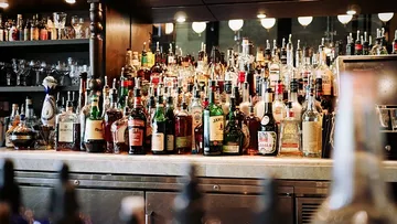 A bar with lots of different liquor bottles on shelves.