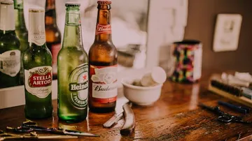 Drei Bierflaschen stehen auf einem Tisch mit Werkzeugen.