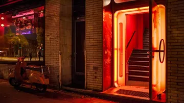 Leuchtende Tür öffnet sich, Treppe führt in dunklen Raum.