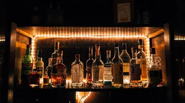Shelf made of bottles glows in dim light.