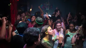Menschen tanzen und feiern in einem dunklen Club.