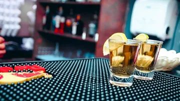 Zwei Gläser mit Getränken stehen auf einer Bar.