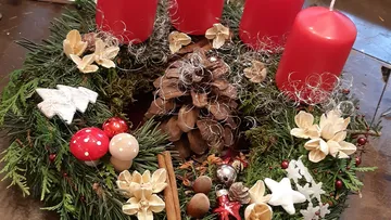 Wreath with red candles, pine cones and Christmas decoration.