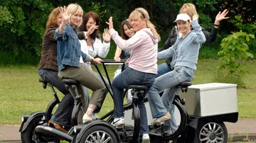 Group women on a special bike in nature.
