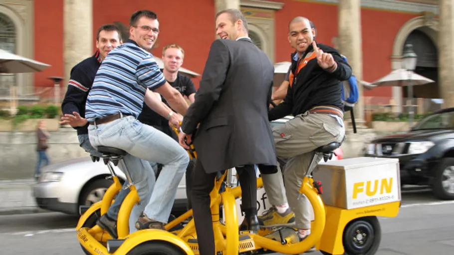 Six men ride together on a yellow pedalboat.
