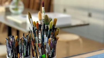 A container of brushes is on a table.