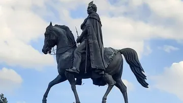 Equestrian statue on a horse surrounded by clouds.