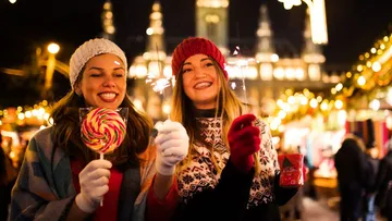 Zwei Frauen genießen die Lichter auf dem Weihnachtsmarkt.
