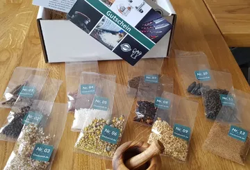 Verschiedene Gewürze in Tüten liegen auf einem Tisch.