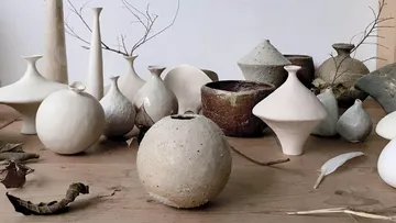 Pottery is placed on a wooden tray in natural light.