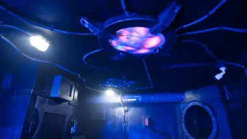 Ceiling with colored light, technical elements and a dark environment.