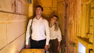 Couple looks up curiously in a decorated room.