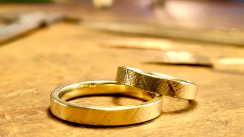 There are two rings on a wooden table.