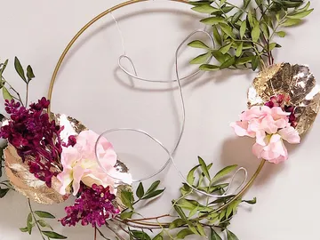 A round wreath with flowers and leaves adorns the wall.