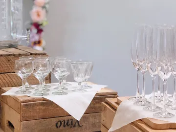 Gläser stehen auf Holzkisten, bereit für ein Event.